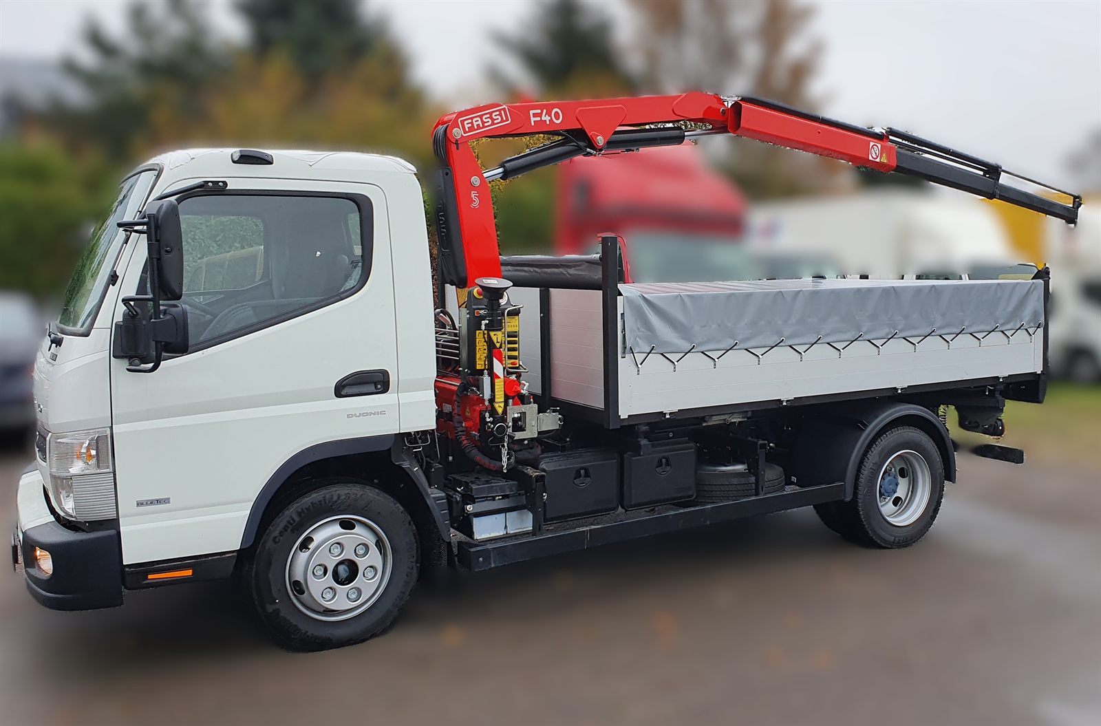 Żuraw Fassi F40 zamontowany za kabiną wywrotki na podwoziu Fuso Canter 9C18