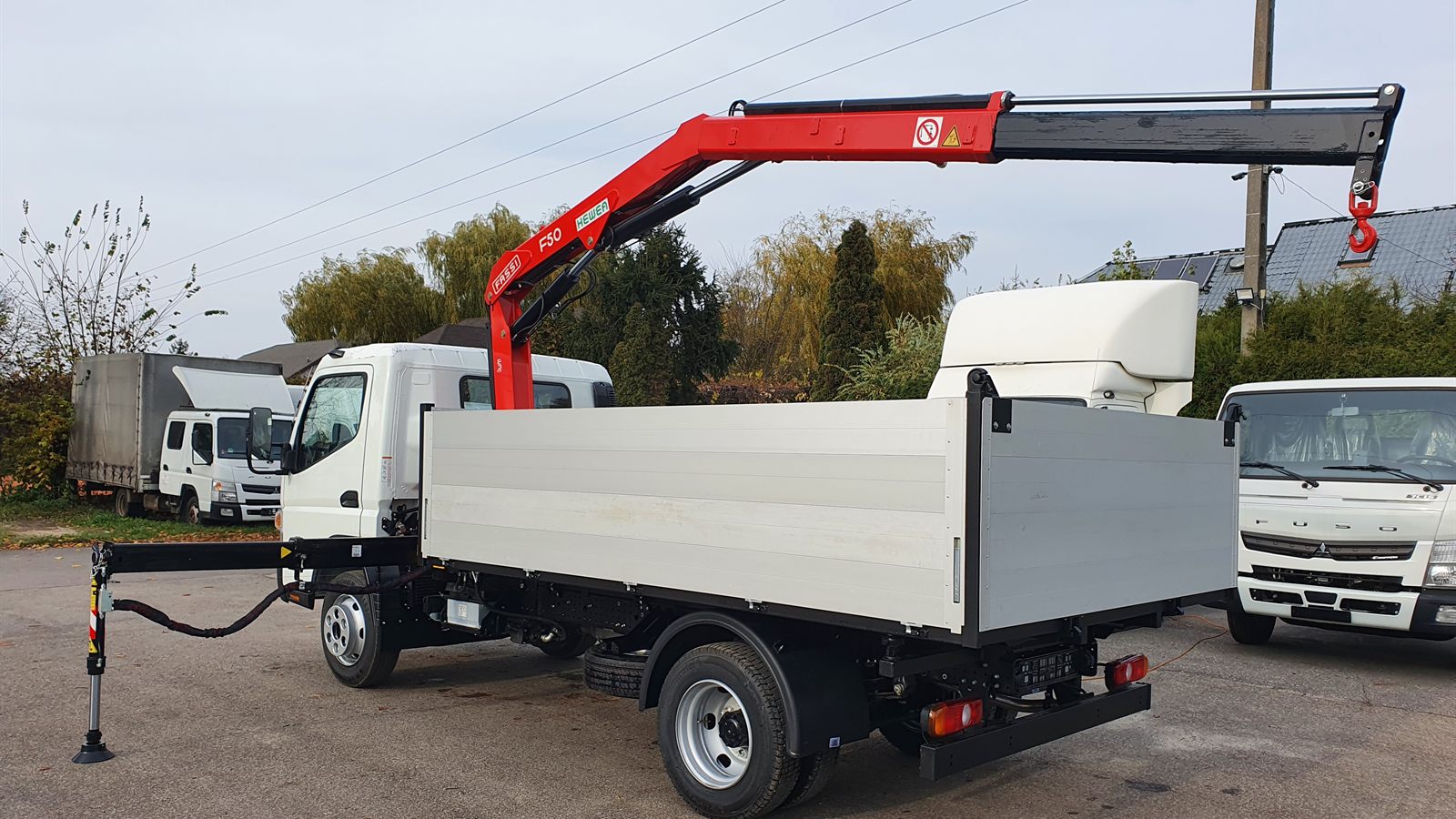 Żuraw Fassi F50 z rozłożoną podporą na skrzyniowym Fuso Canter 9C18