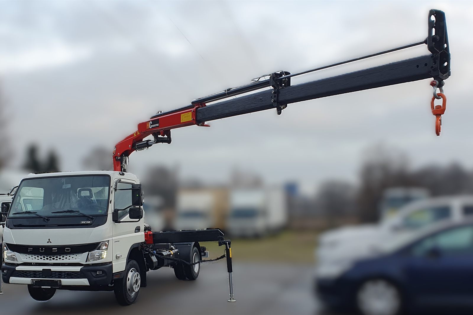 Żuraw HC 80 z wysięgnikiem rozłożonym nad platformą Fuso Canter 9C18